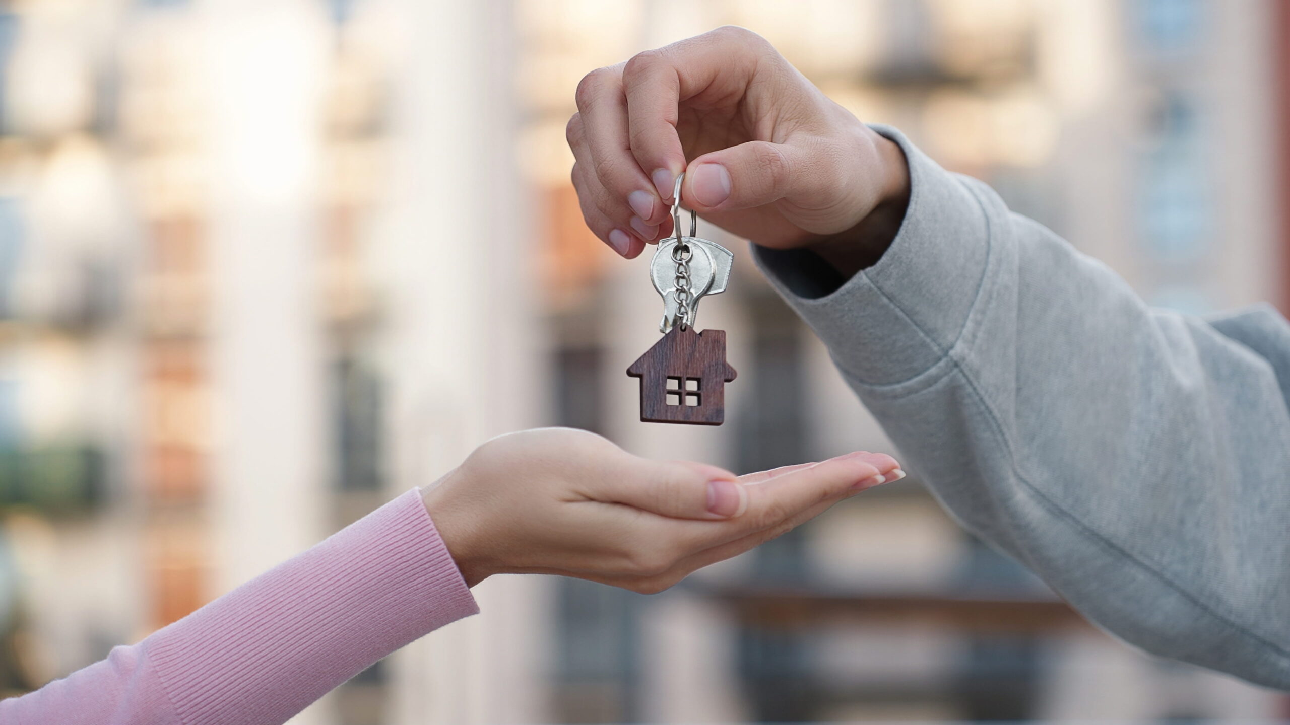 Sarasota rental property management represented by keys passing hands.