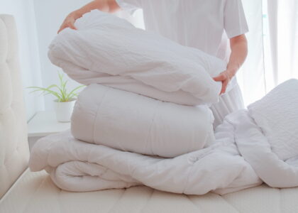 Vacation rental turnover cleaning. Cleaner changing bed linens.